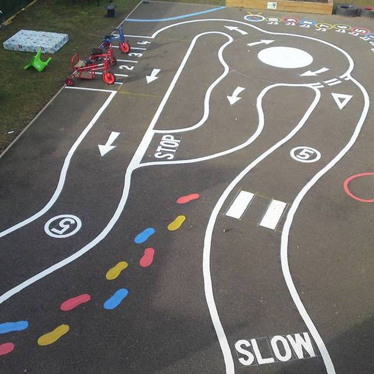 Colourful thermoplastic playground roadway and activity trail markings at a school