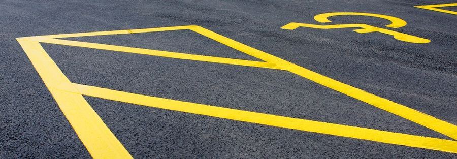 Disabled parking symbol and yellow hatched markings in a car park