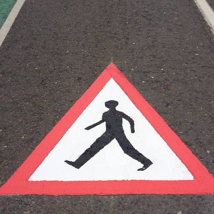 Preformed pedestrian warning triangle road marking on asphalt